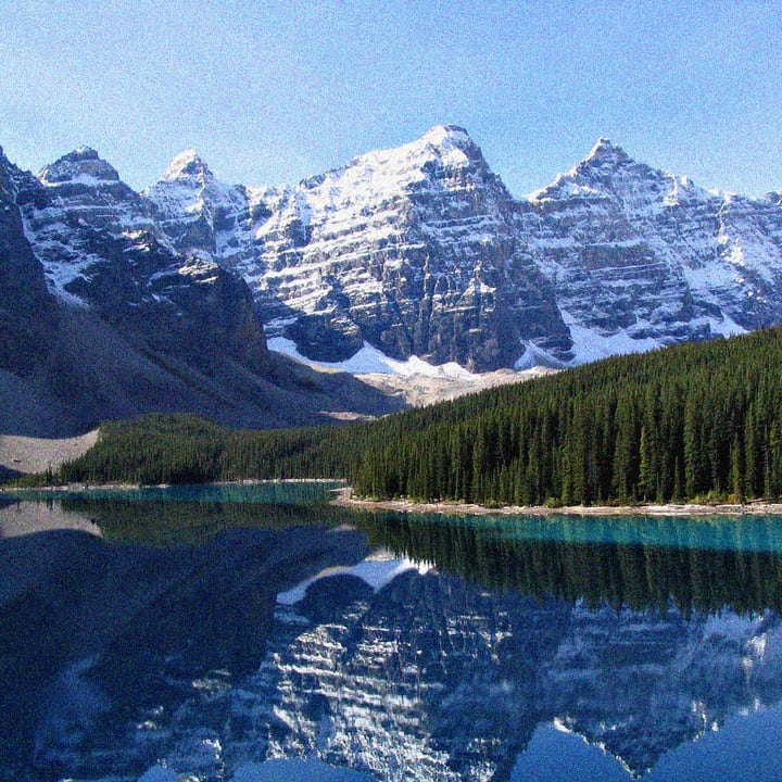 Before: a mountain lake photograph covered in coarse, colored grain