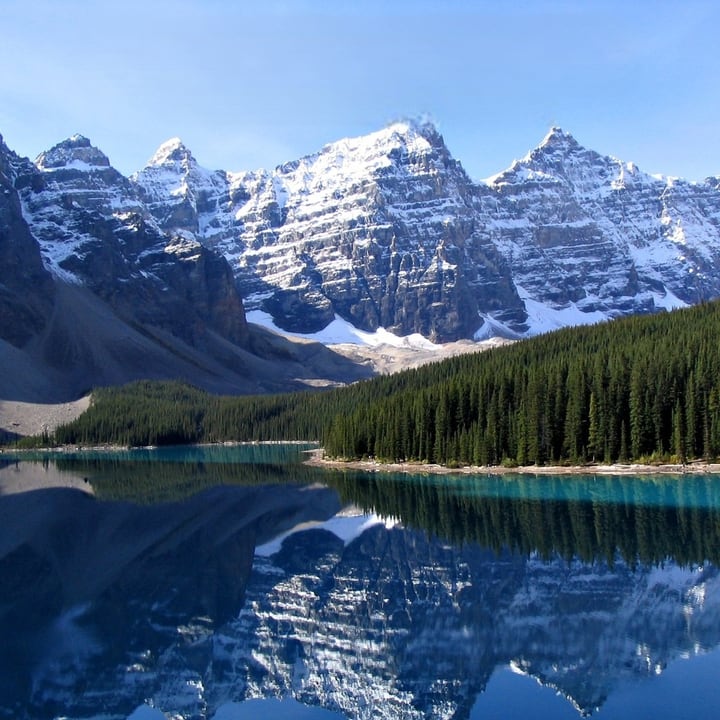 After: the same lake and peaks with all the text removed and the sky filled in